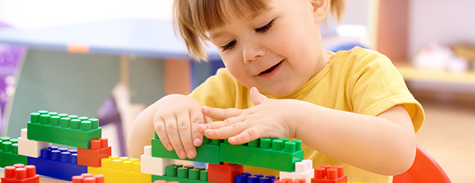 Child playing with multi-color blocks