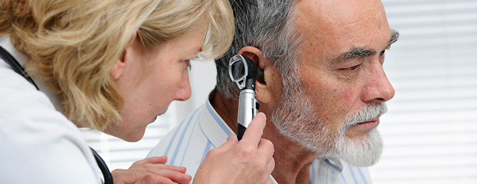 Physician examing a patient's ear with a scope