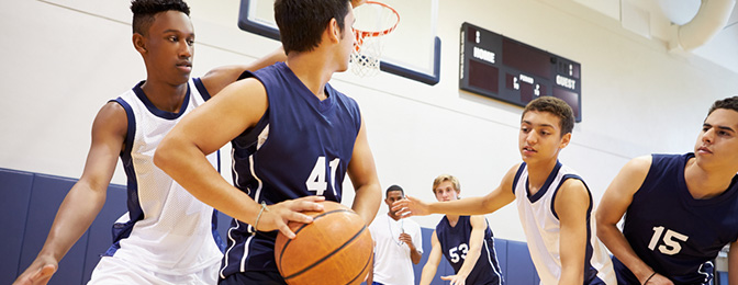 Teenage boys playing basketball.