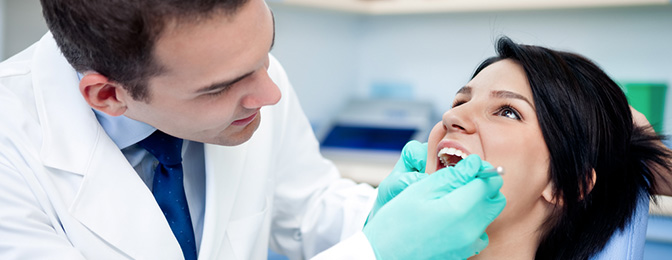 Young doctor examining a patient's mouth