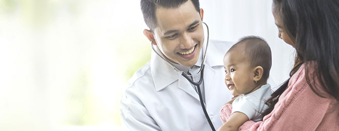 Doctor using stethoscope to check infants heart beat.